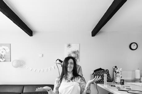 Bride puts hands up whilst hair is styled tattooed arm york wedding