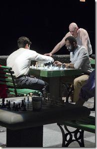 In a duel to the end, (left to right) Rey Reyes (Raúl Castillo) competes against chess hustler Cash (Cedric Mays) while John (Mike Cherry) and Dr. Lee (Gordon Chow) observe in Teatro Vista’s Fish Men, written by Cándido Tirado and presented by Goodman Theatre (April 7 – May 6).