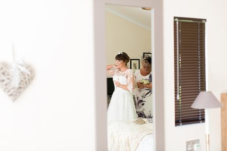 York Wedding Photography at Barmbyfield Barns bride getting into dress in mirror