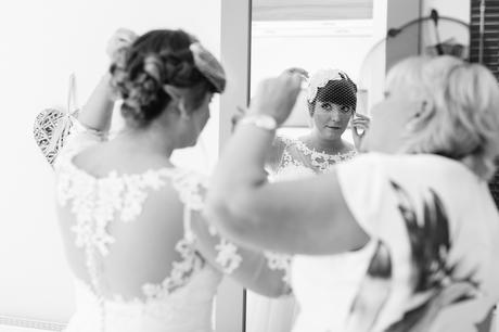 Bride adjusting hair in mirror