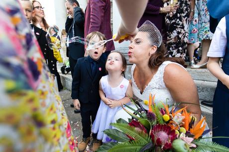 Bride blows bubbles with kids at wedding at the Asylum in London