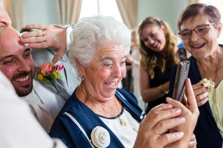A fun Yorkshire Wedding grooms mother smiles and laughs on skype call with family
