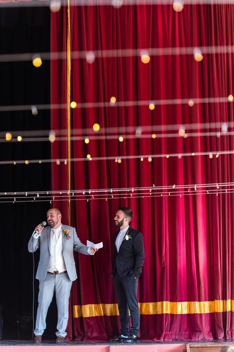 Grooms giving speeches in front of red curtain A fun Yorkshire Wedding