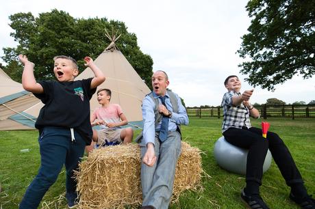 Villa Farm Weddings guests having fun sitting on hay bales