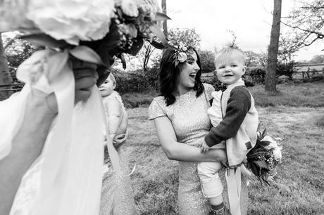 Fun, candid photo of bridesmaid holding baby