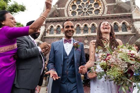 Bride and groom laugh as confetti is thrown St. Stephens Hampstead Wedding