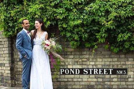 Bride and groom pose in front of pond street sign