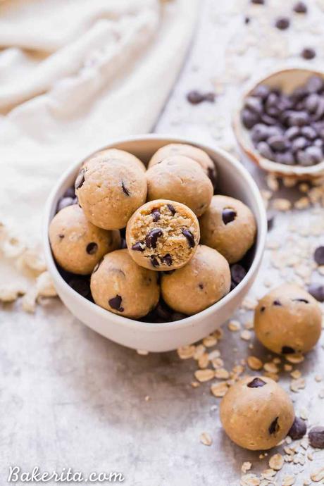 Oatmeal Chocolate Chip Cookie Dough Bites: Gluten Free & Vegan. Stacked in a bowl with oats and chocolate chips.