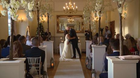 the bride and groom kiss as their guests applaud them being husband and wife at Nunsmere Hall