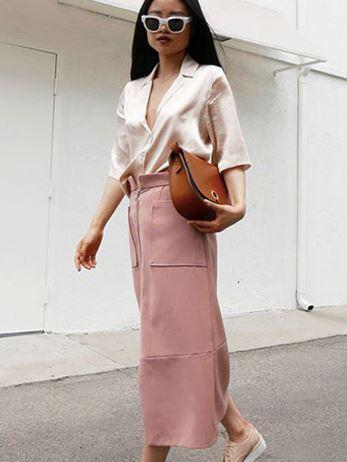 tan handbag styled with off-white shirt and pink trousers