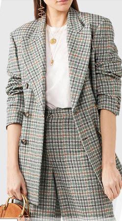 White top worn under soft pastel green oversized checkered suit with slick middle parting hair.