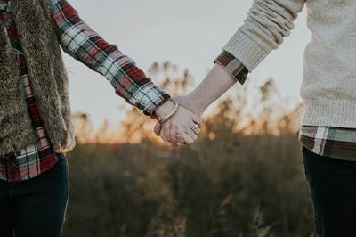 couple-walking-hands-in-hands-on-beach