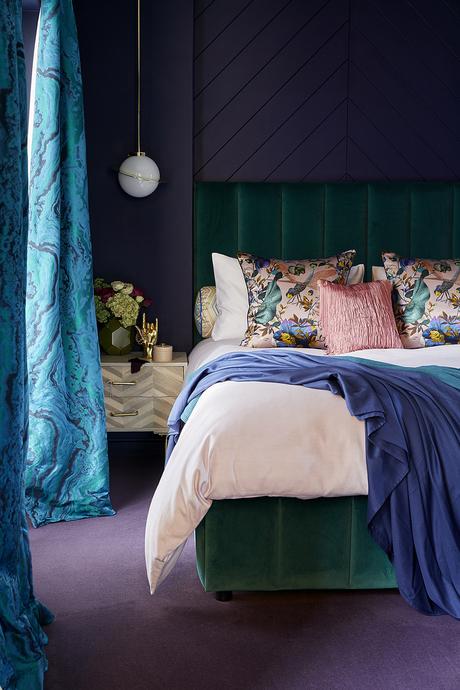 The Idea Home Show- Styled by Sophie Robinson. Dark and moody bedroom with colourful accessories. Green velvet bed.