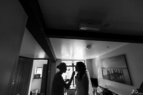 Silhouette of bride having makeup put on
