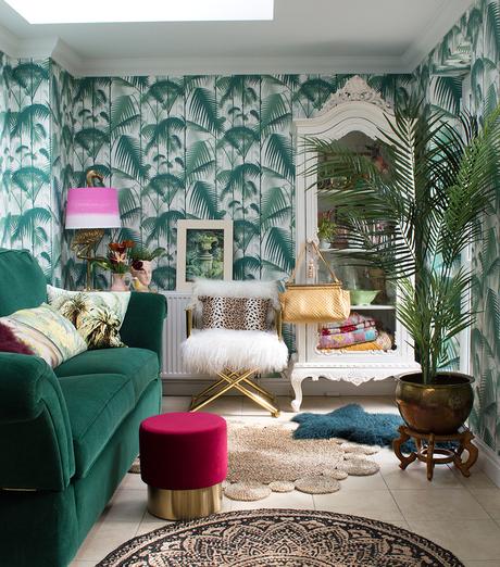 Tropical inspired living room featuring; Palm Jungle wallpaper by Cole & Son, green velvet sofa, flamingo lamp and plenty of layers of house plants.