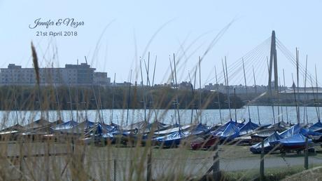 a shot of southport marina and bridge through wavy long grass on a summers day