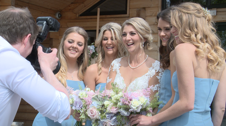 the bridesmaids have a giggle with the wedding photographer Daniel Lloyd outside Styal Lodge in Cheshire