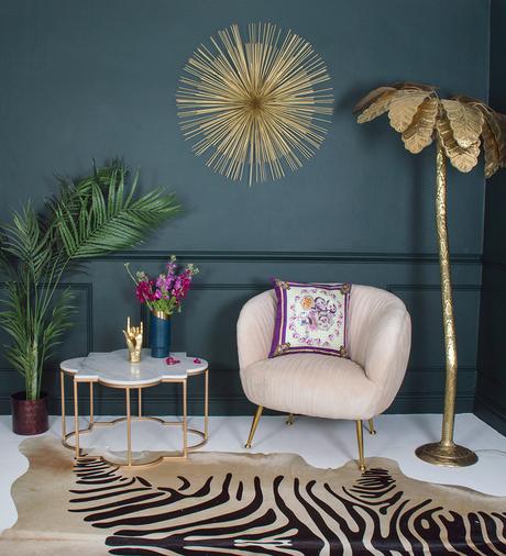 Dark and moody living room inspiration. Pair dark walls with a zebra cowhide rug, gold palm tree floor lamp and a blush pink velvet armchair, for an uber glam, eclectic living room. 