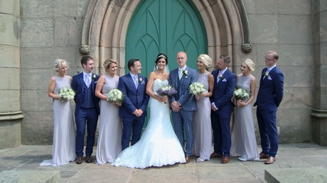 the bridal party pose with the bride and groom in lilac and navy 