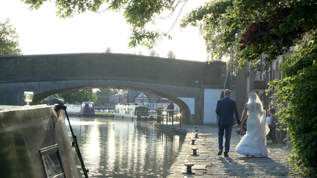 the bride and groom walk back towards the Blue mallard down the tow path of the canal as the sun begins to set behind the trees