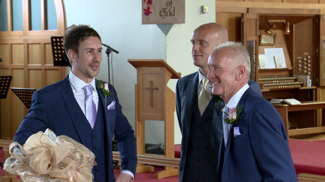 The groom waits by the alter in St Johns church in burscough looking nervous with his best man and dad