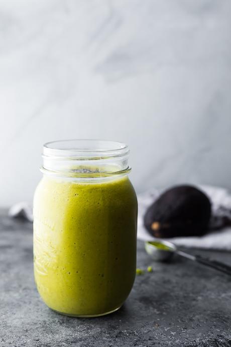 Mango Matcha Smoothie in mason jar with avocado in background