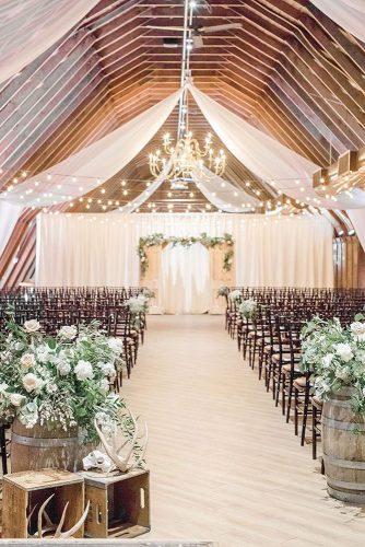 barn wedding ceremony decorated with white cloth wine barrel and greenery lauren fair