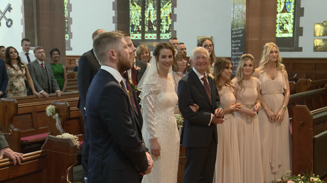the bridal party smile as they stand at the top of the aisle at St Peters church