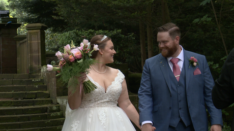 the bride and groom have a laugh and a chat as they walk towards their photographer Ioan at thornton manor