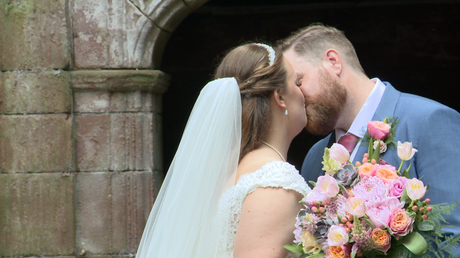 the bride and groom have a kiss for the wedding video and photographer