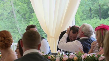 silver service singers singing waiter gets a kiss on the head from the father of the groom during a surprise routine at thornton manor lakeside marquee