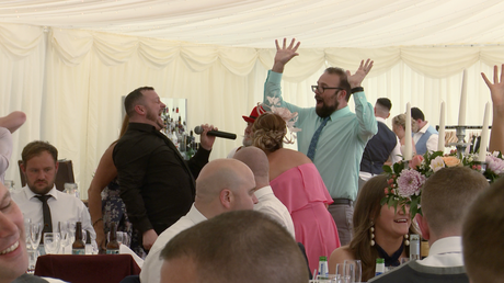 the silver service waiter has guests singing along during a wedding gig at the lakeside marquee at Thornton manor