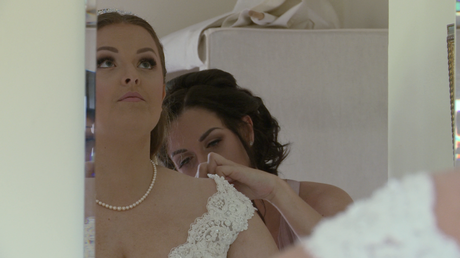 the bride looks up to compose herself as she sees herself in the mirror for the first time