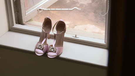 a strappy pink bridal sandal perches on a window sill at thornton manor in the wirral