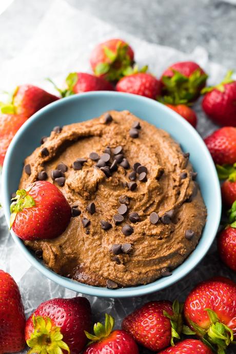 Creamy Chocolate Dessert Hummus in blue bowl surrounded by strawberries