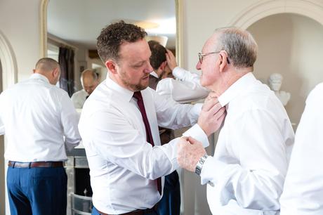Groom helps his dad with buttonhole