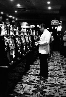 DAFwhite-Gal4 Sean Connery takes a solitary break to play the slots. Note the dinner jacket's angled hip pockets and the long back vents. Photo by Terry O'Neill, 1971.