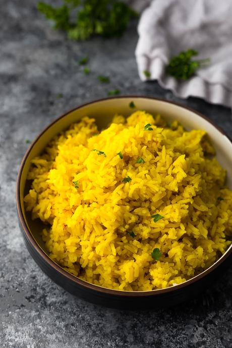 bowl with turmeric yellow rice on gray background