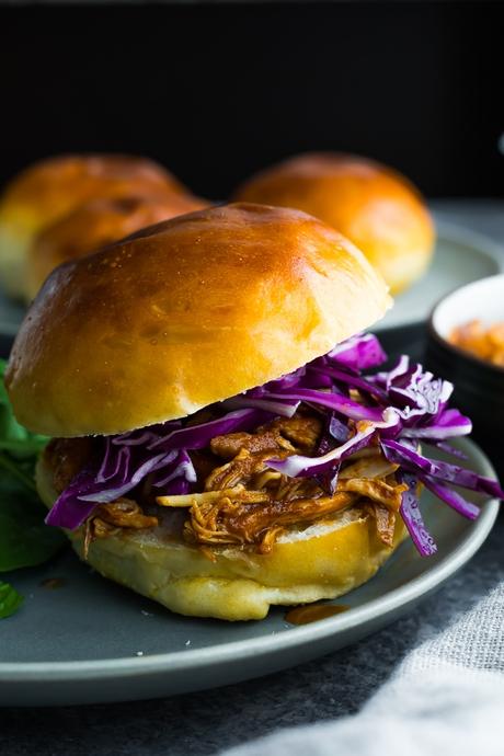 crockpot bbq chicken on a buger bun, topped with purple cabbage