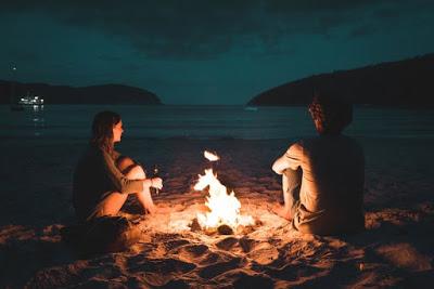 couple-sitting-beside-bonfire