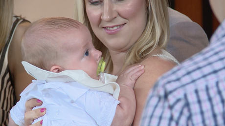 a close up of mum holding her baby bioy Archie at st pauls of the cross in Burtonwood