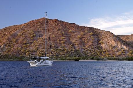 Sailboat at anchor in front of rugged desert hills off Baja