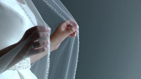 a bride delicately holds on to her beaded wedding veil before getting married in Birkenhead