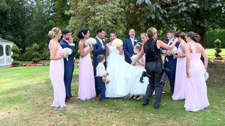 guests joke and laugh as the wedding photographer Jane Hockey tries to arrange them for their wedding photos at thornton hall