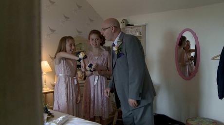a wedding video still watching father of the bride, their grandad, seem impressed at the girls flower and minion corsages for his daughters wedding at Abels harp