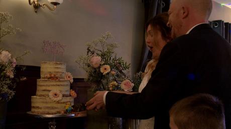 the bride and groom nearly knock the naked cake over as they cut it and the knife gets stuck near one of their Minions