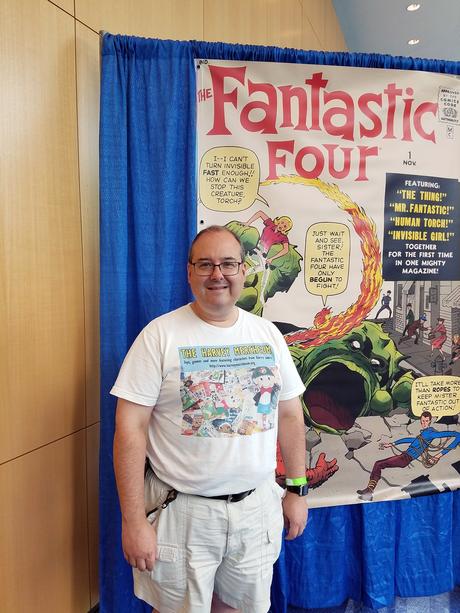 Jonathan Sternfeld standing in front of poster-sized cover of Fantastic Four # 1