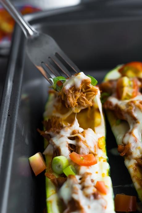 Fork scooping from the pulled pork stuffed zucchini boats