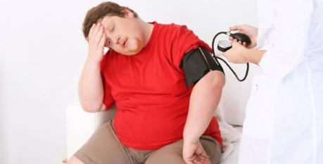 An obese man upset at his blood pressure results at an examination.