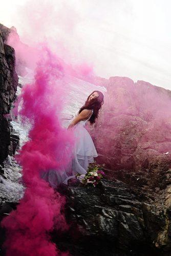 beach styled shoot bride among the rocks shrouded in pink smoke alexi